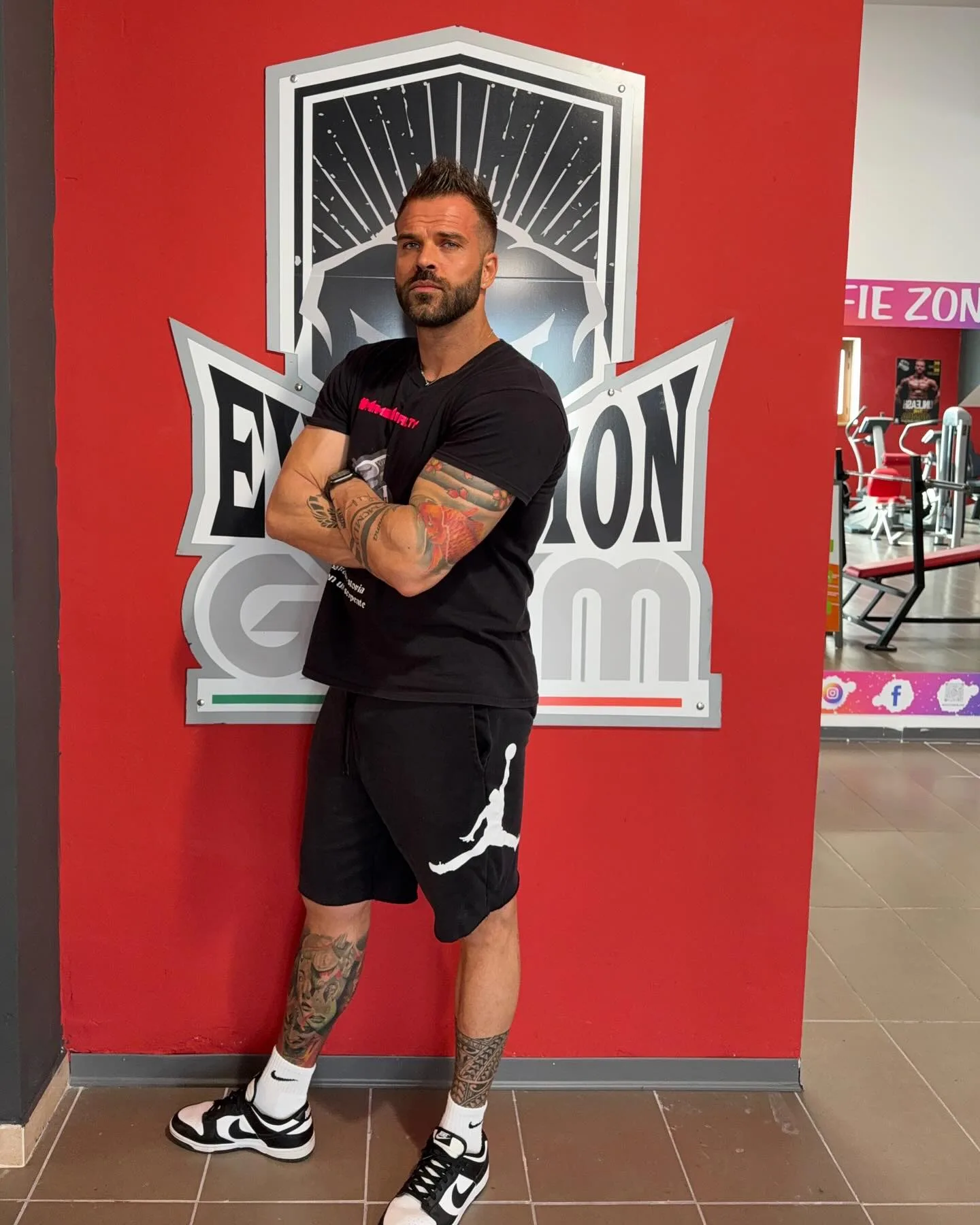 Ivan Fulco, fondatore di Evolution Gym, davanti al logo della palestra